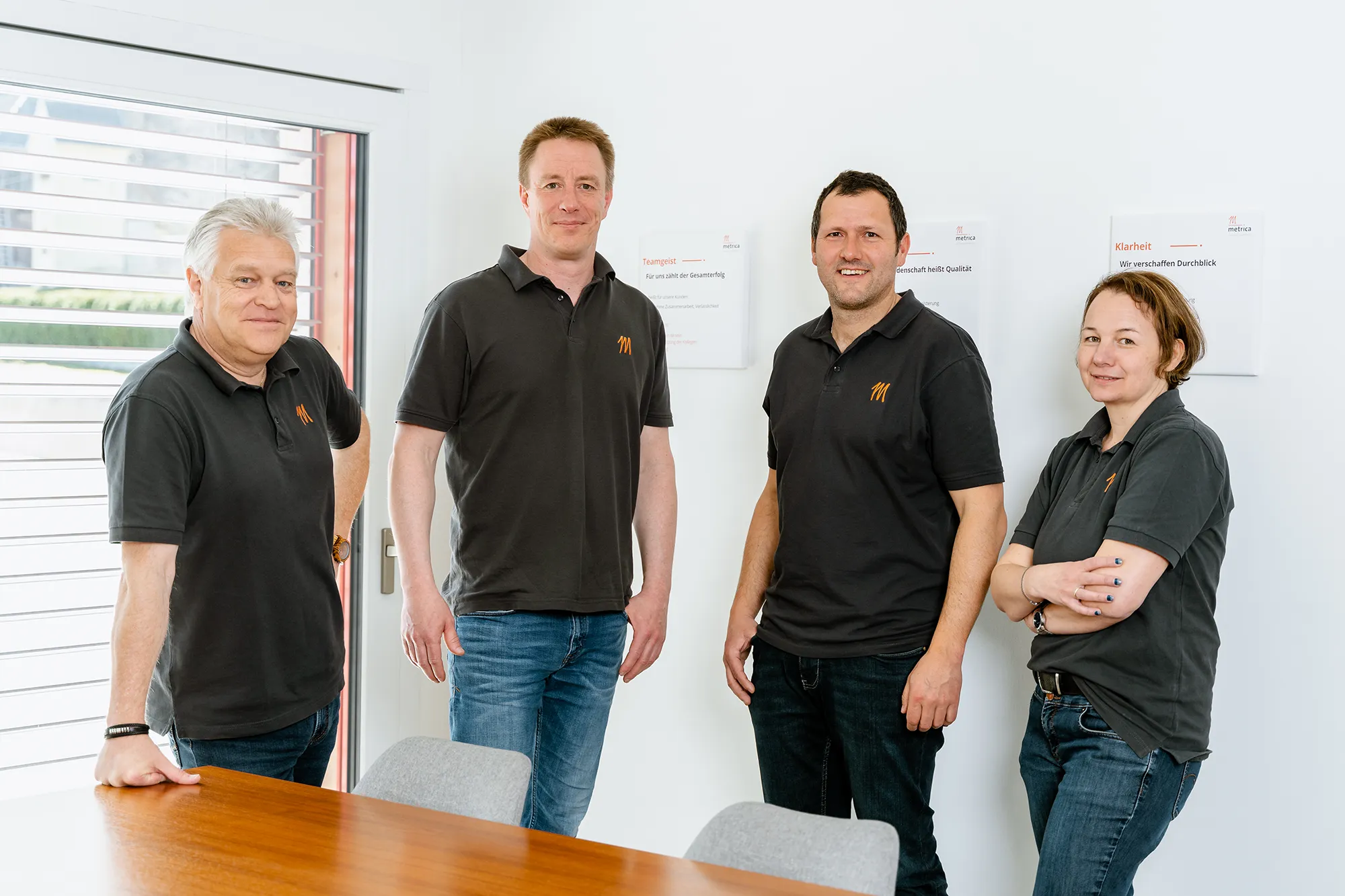 SquadTwenty, vereint in schicken Polos, strahlt selbstbewusst in einem lebendigen Studio - die Experten für Social Media Marketing der Werbeagentur Kärnten. – SquadTwenty Werbeagentur Kärnten