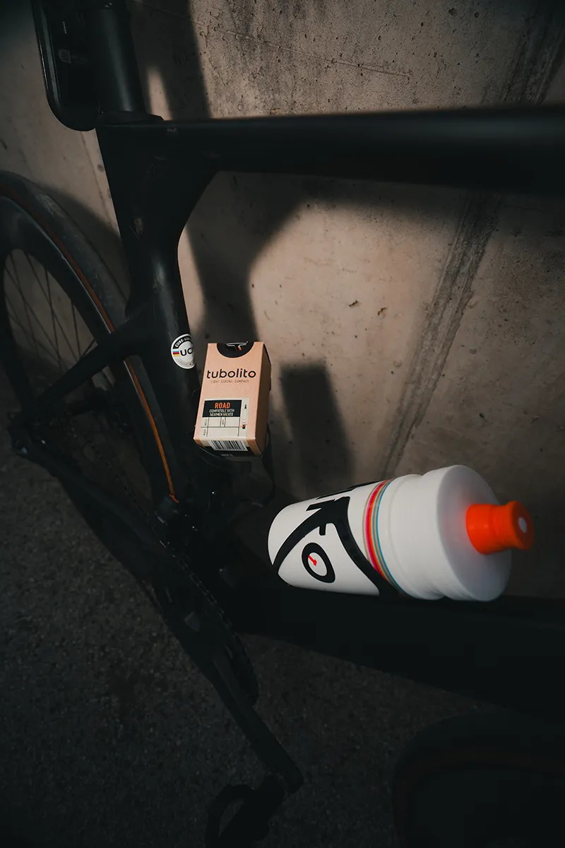 Schlichter schwarzer Fahrradrahmen mit einem Tubolito-Rohr in Kastenform und einer weißen Wasserflasche mit kunstvollen Details, die sicher befestigt ist. – SquadTwenty Werbeagentur Kärnten