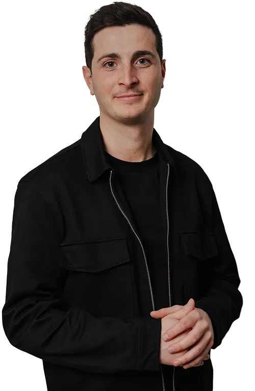 Eine selbstbewusste Person mit kurzen dunklen Haaren in schlichter schwarzer Kleidung blickt nach vorne und präsentiert die innovative Markenästhetik von SquadTwenty. – SquadTwenty Werbeagentur Kärnten